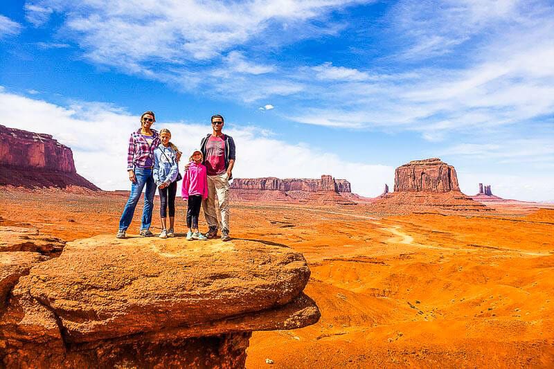 family standing on rock in monument valley