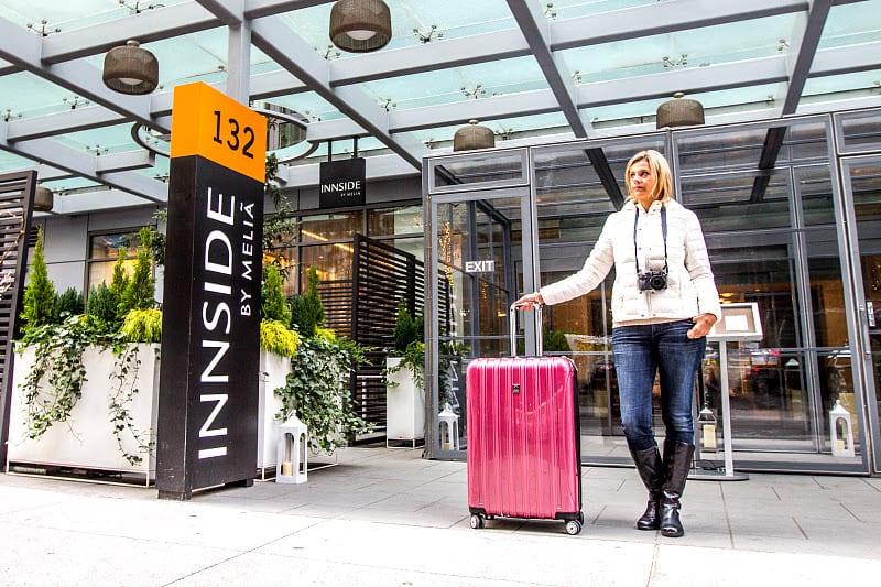 delsey-suitcase woman standing outside hotel with suitcase