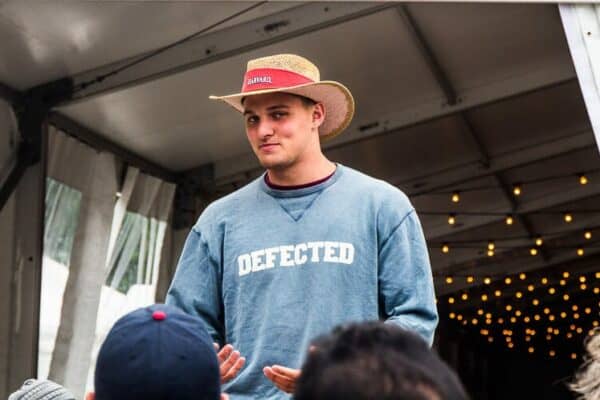 a harvard student tour guide wearing a hat