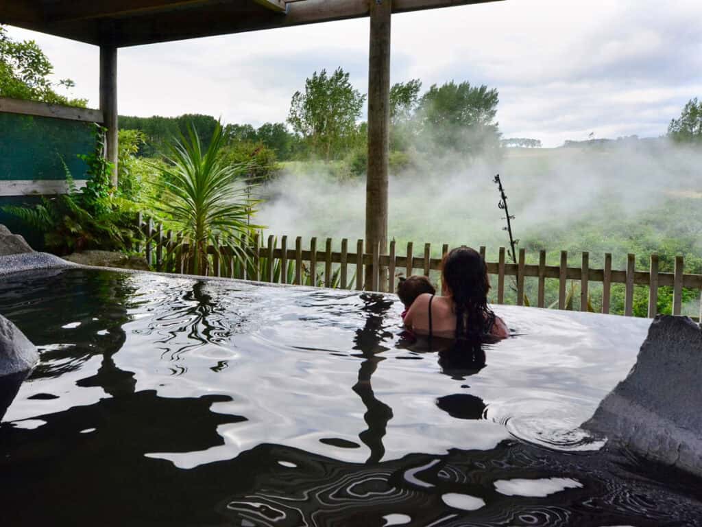 A woman and her baby inside a hot spring and spa pool in Rotorua,
